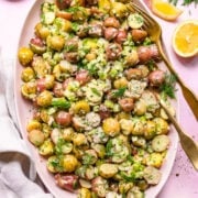 Overhead view of vegan potato salad on a plate garnished with dill.