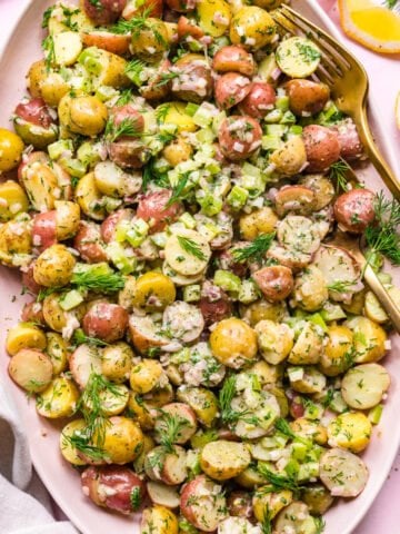 Overhead view of vegan potato salad on a plate garnished with dill.