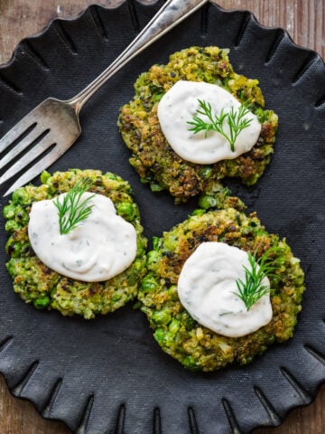 Overhead view of pea fritters with lemon dill sauce on top.