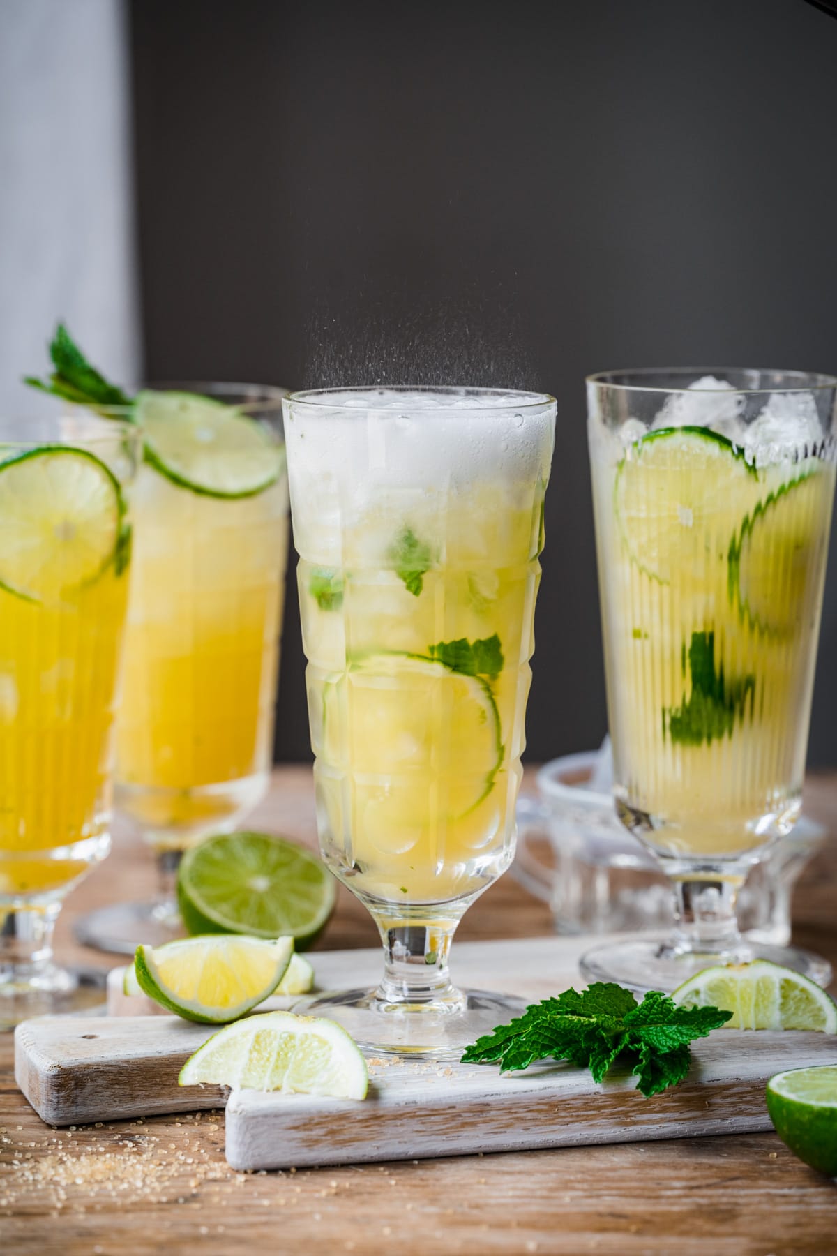 Side view of 2 pineapple mojito cocktails in highball glasses with mint garnish. 