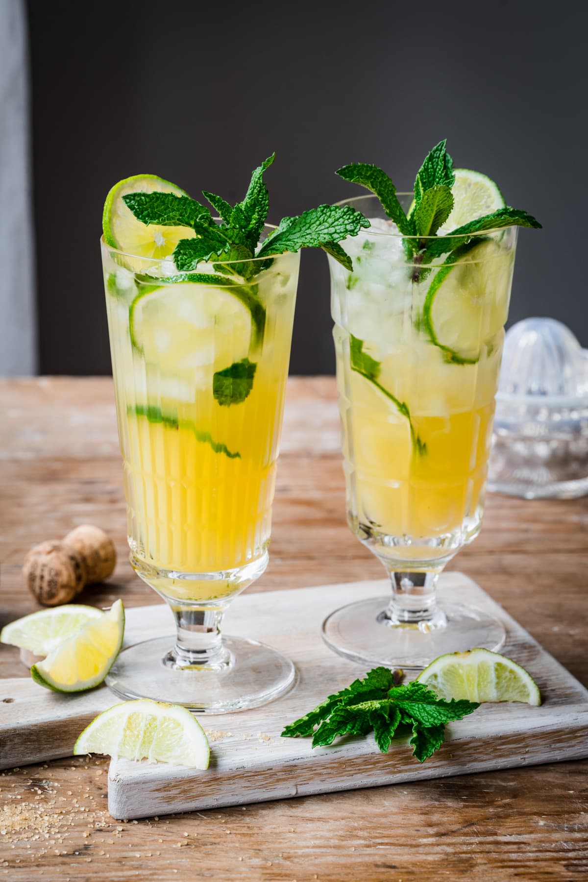 Side view of 2 pineapple mojito cocktails in highball glasses with mint garnish. 