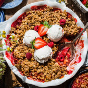 overhead view of vegan and gluten free strawberry rhubarb crisp with vanilla ice cream.