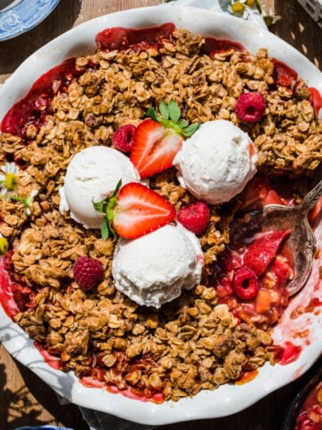 overhead view of vegan and gluten free strawberry rhubarb crisp with vanilla ice cream.