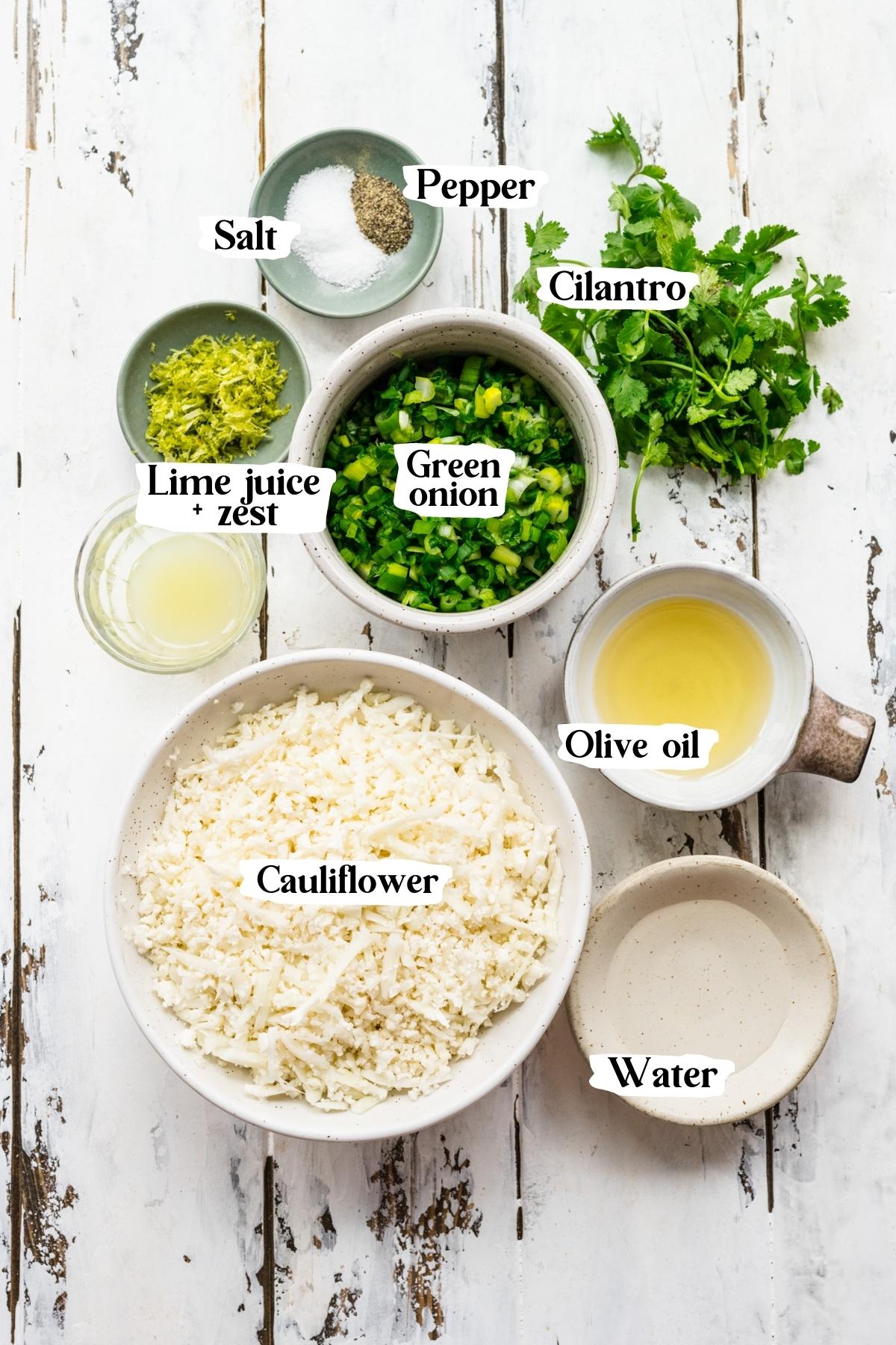 Overhead view of cilantro lime cauliflower rice ingredients, including cauliflower and green onion.