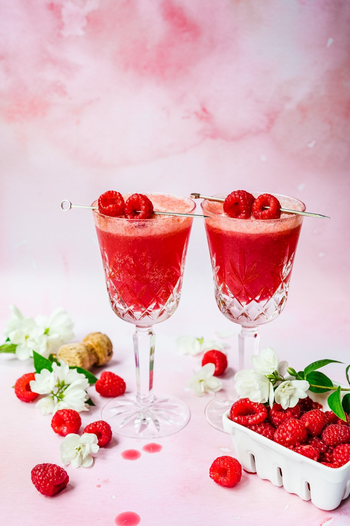 Front view of raspberry mimosa with skewered raspberries for garnish.