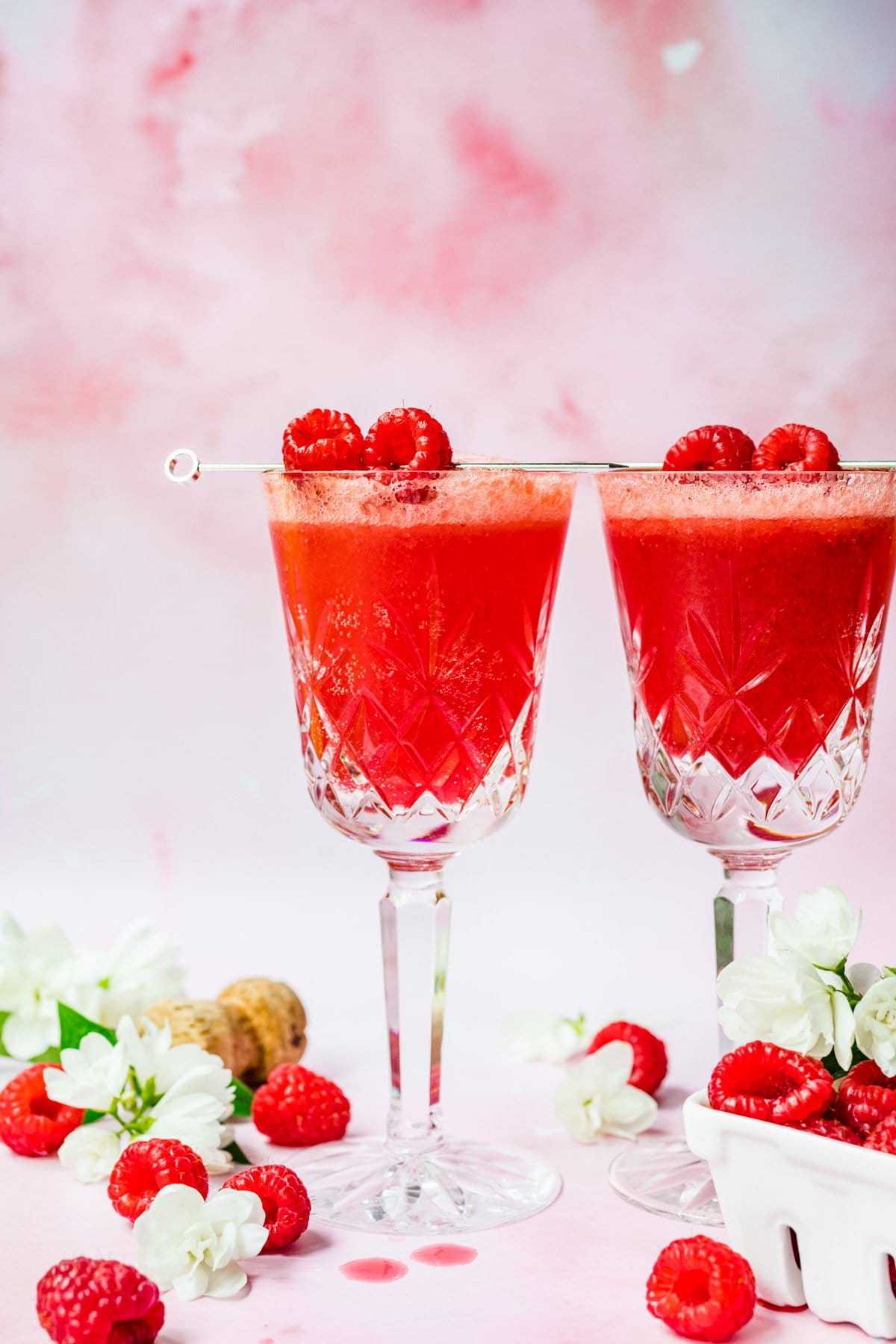 Front view of raspberry mimosa with skewered raspberries for garnish.