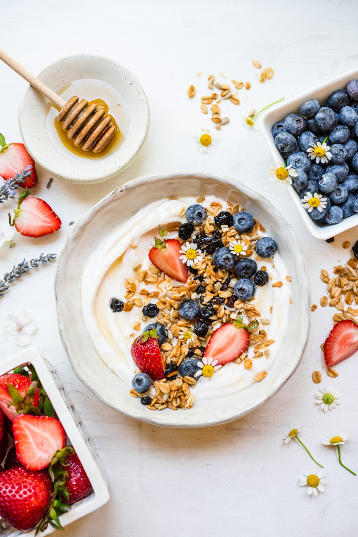 Overhead of finished berry granola in white bowl on top of yogurt.