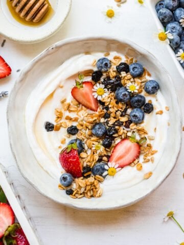 Close up image of finished berry granola on yogurt in bowl.