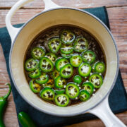 Overhead view of jalapeno simple syrup in a white saucepan.