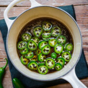 Overhead view of jalapeno simple syrup in a white saucepan.