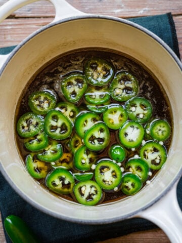 Overhead view of jalapeno simple syrup in a white saucepan.