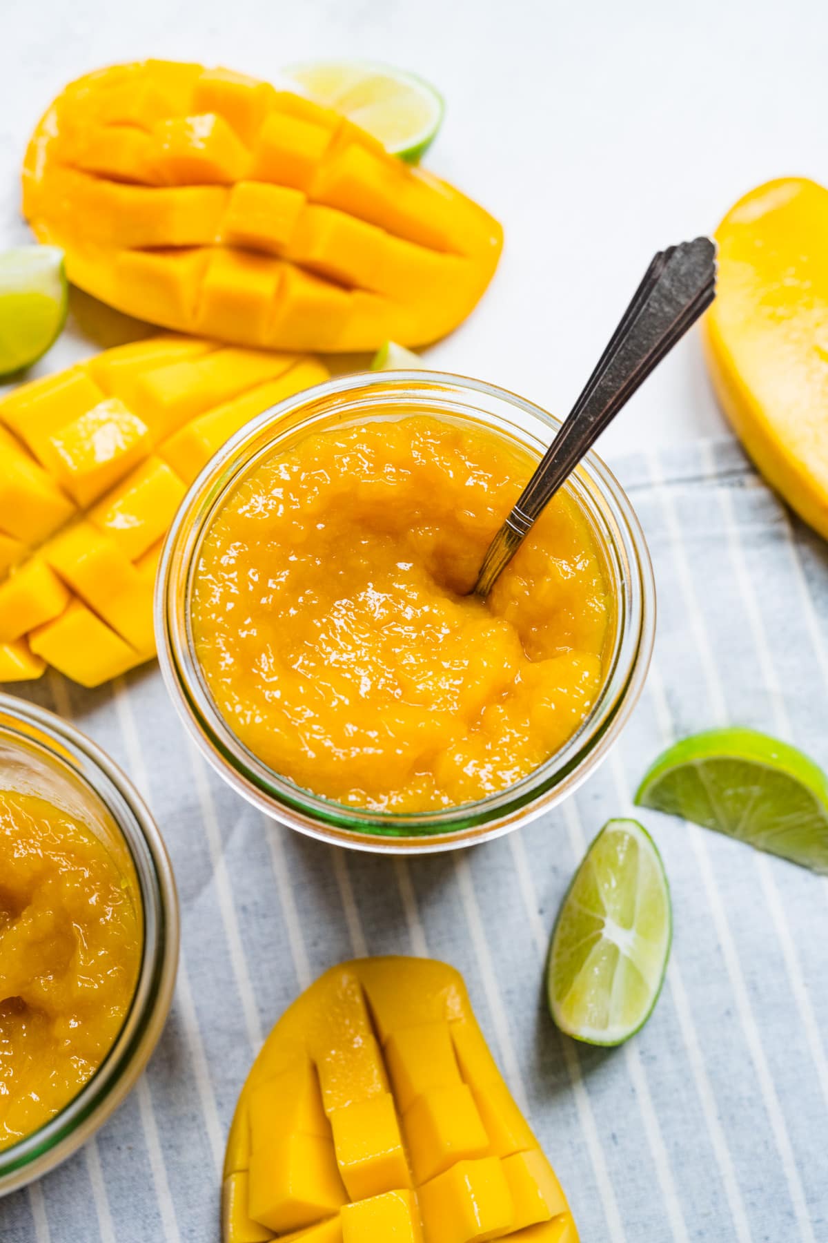 Finished mango jam in jar with spoon in it.