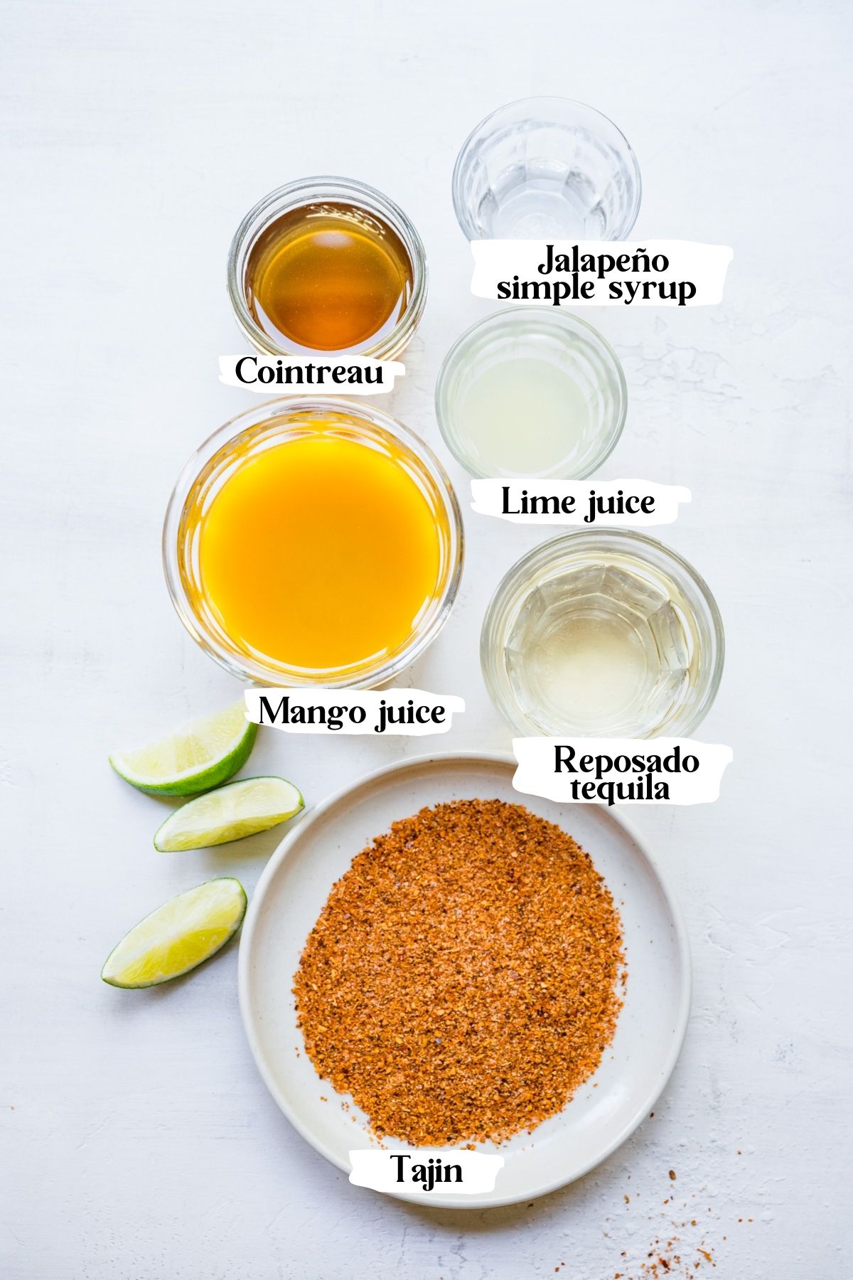 Overhead of mango margarita ingredients including mango juice, reposado tequila and lime juice.