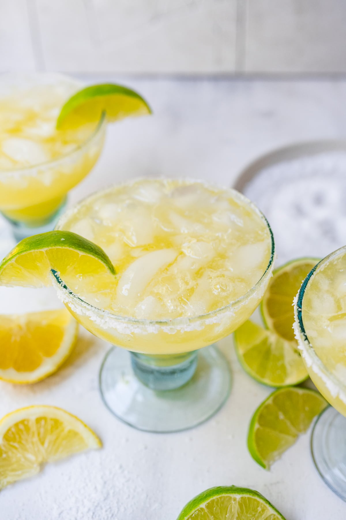 Overhead of finished margarita mocktails with lime and rim.