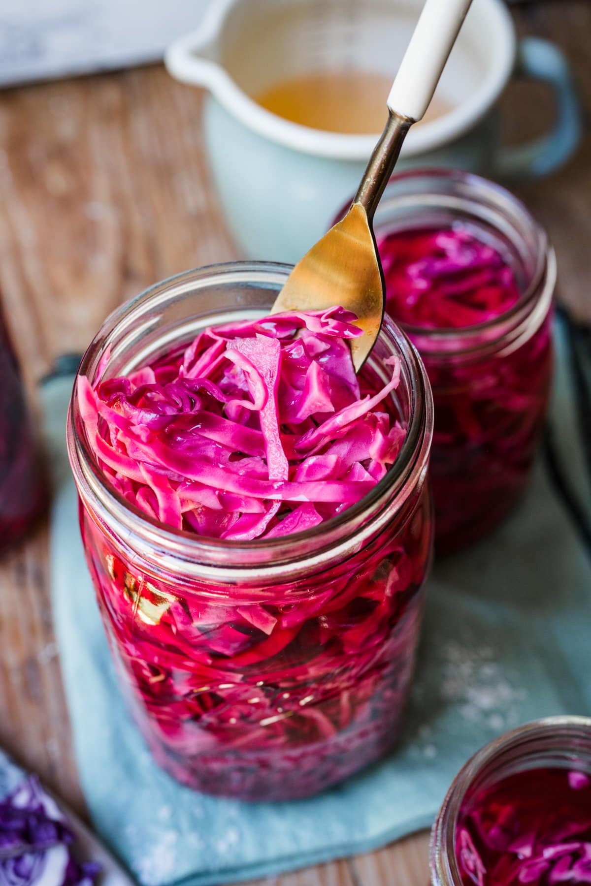 Close up view of fork holding cabbage in jar.