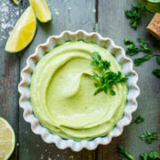 Overhead shot of avocado crema in a ramekin garnished with cilantro.