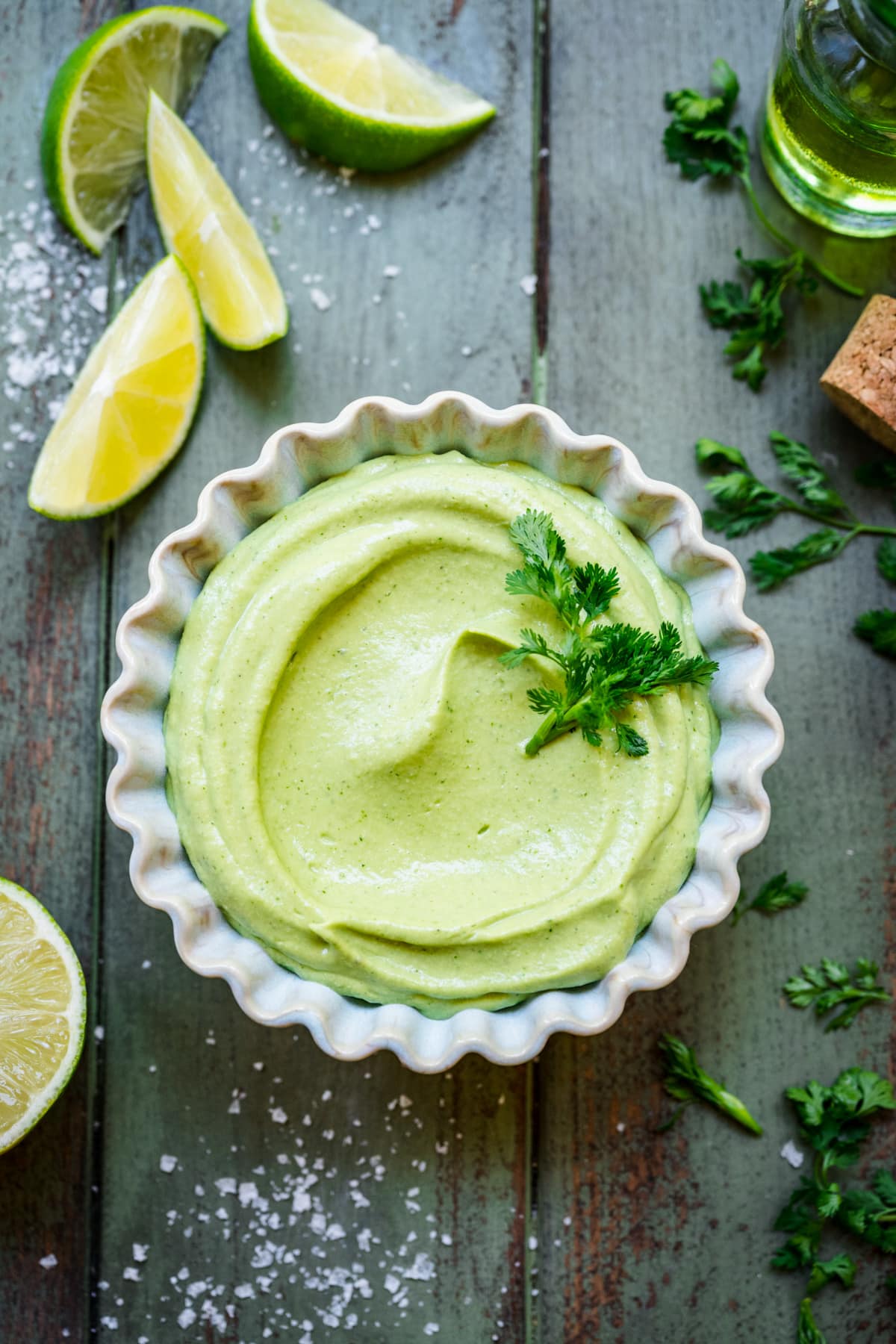 Overhead shot of avocado crema in a ramekin garnished with cilantro.