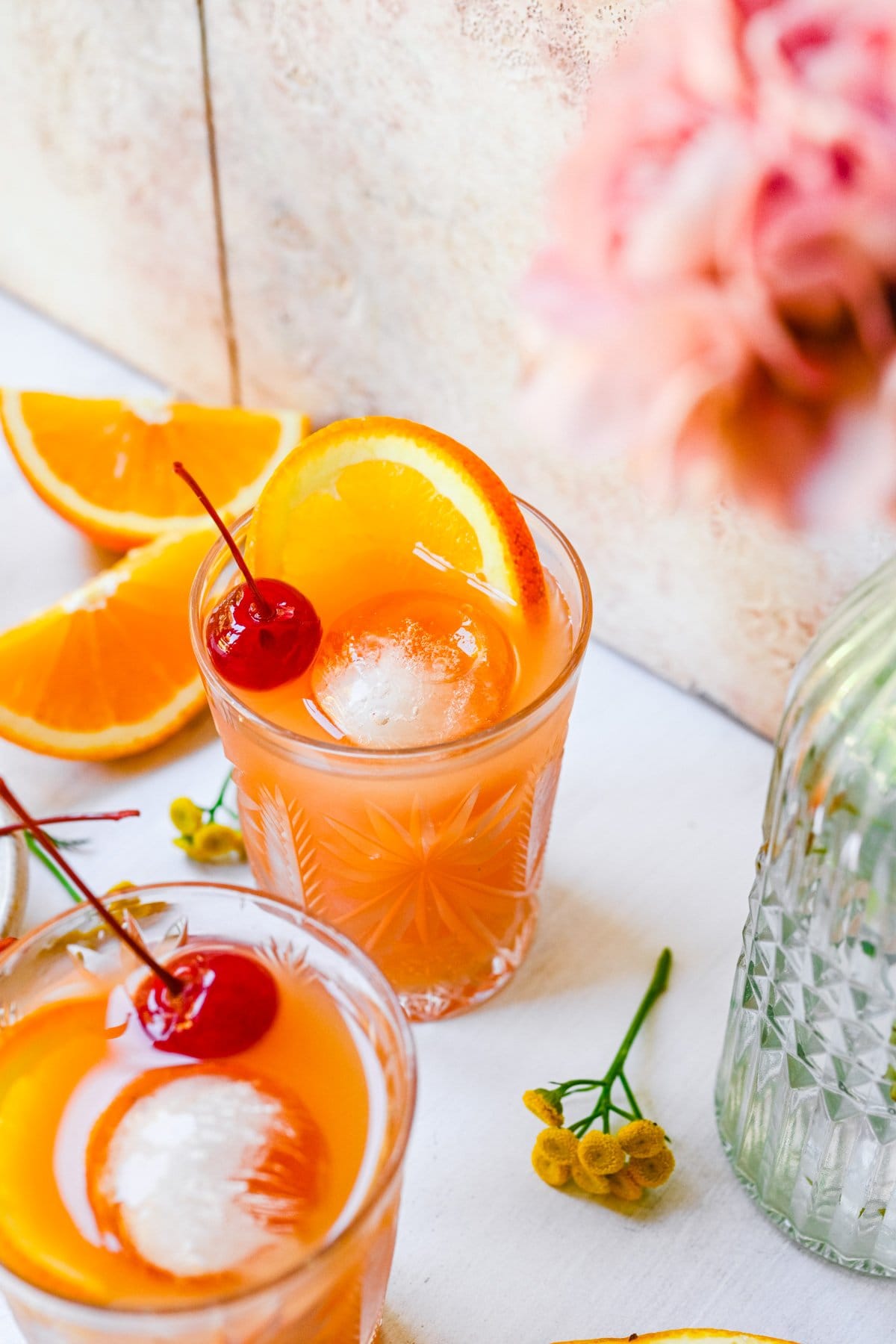 Front view of amaretto stone sour, garnished with orange and maraschino cherry.