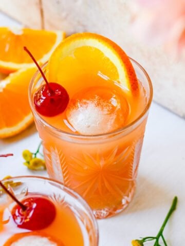 Front view of amaretto stone sour garnished with a cherry and orange.