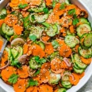 close up overhead view of carrot cucumber salad in white bowl.