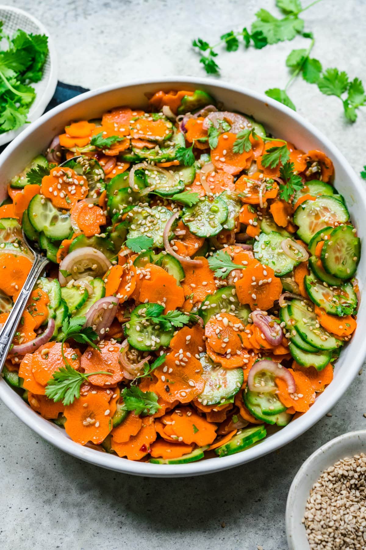 close up overhead view of carrot cucumber salad in white bowl. 