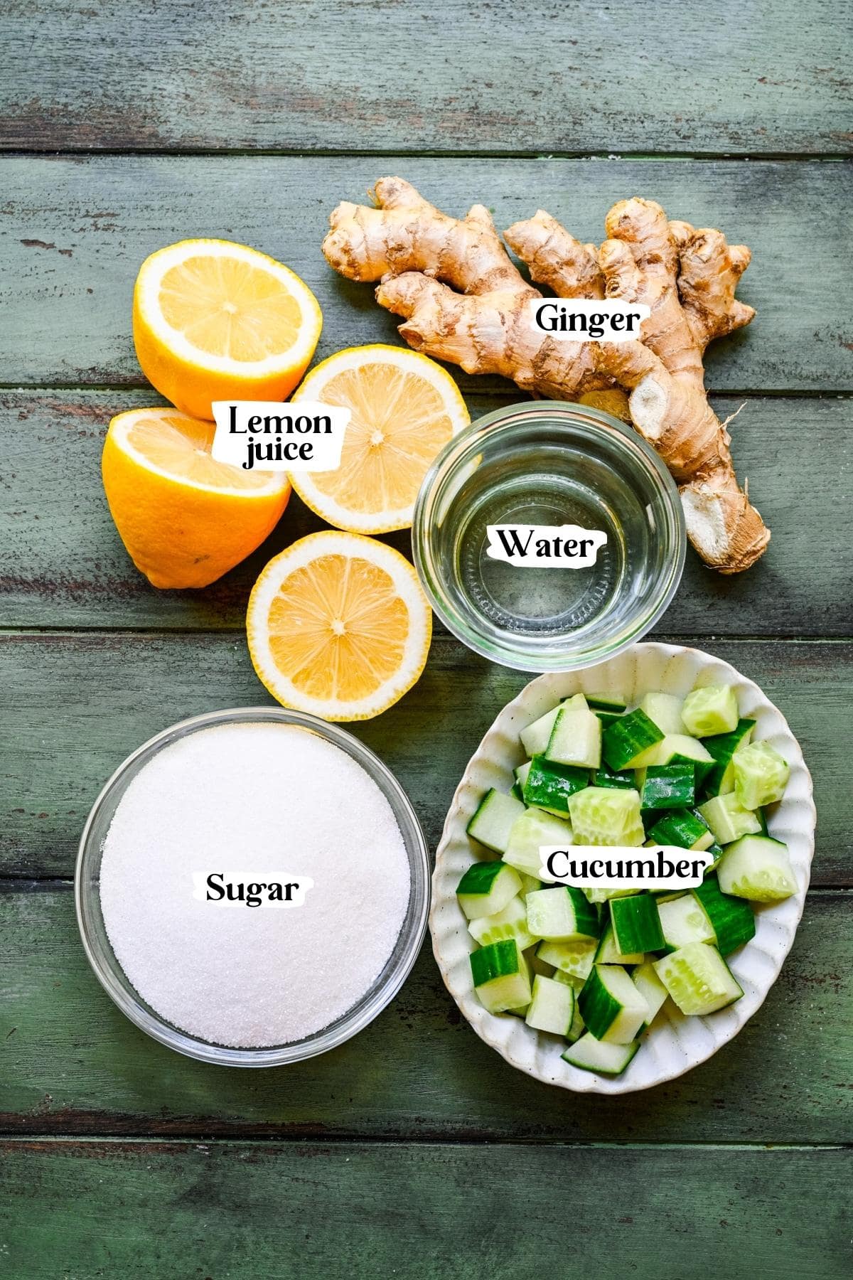 Overhead view of cucumber ginger limeade ingredients, including sugar, water, cucumber, lemon, and ginger.