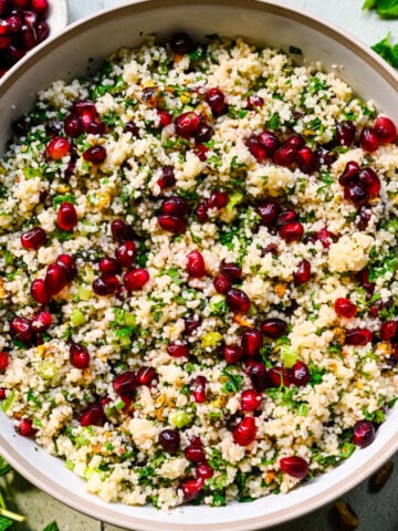 Close up of finished pomegranate couscous salad in a bowl.