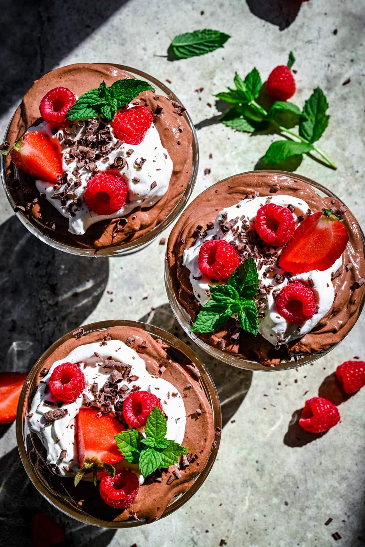 overhead view of tofu chocolate mousse topped with whipped cream and berries.