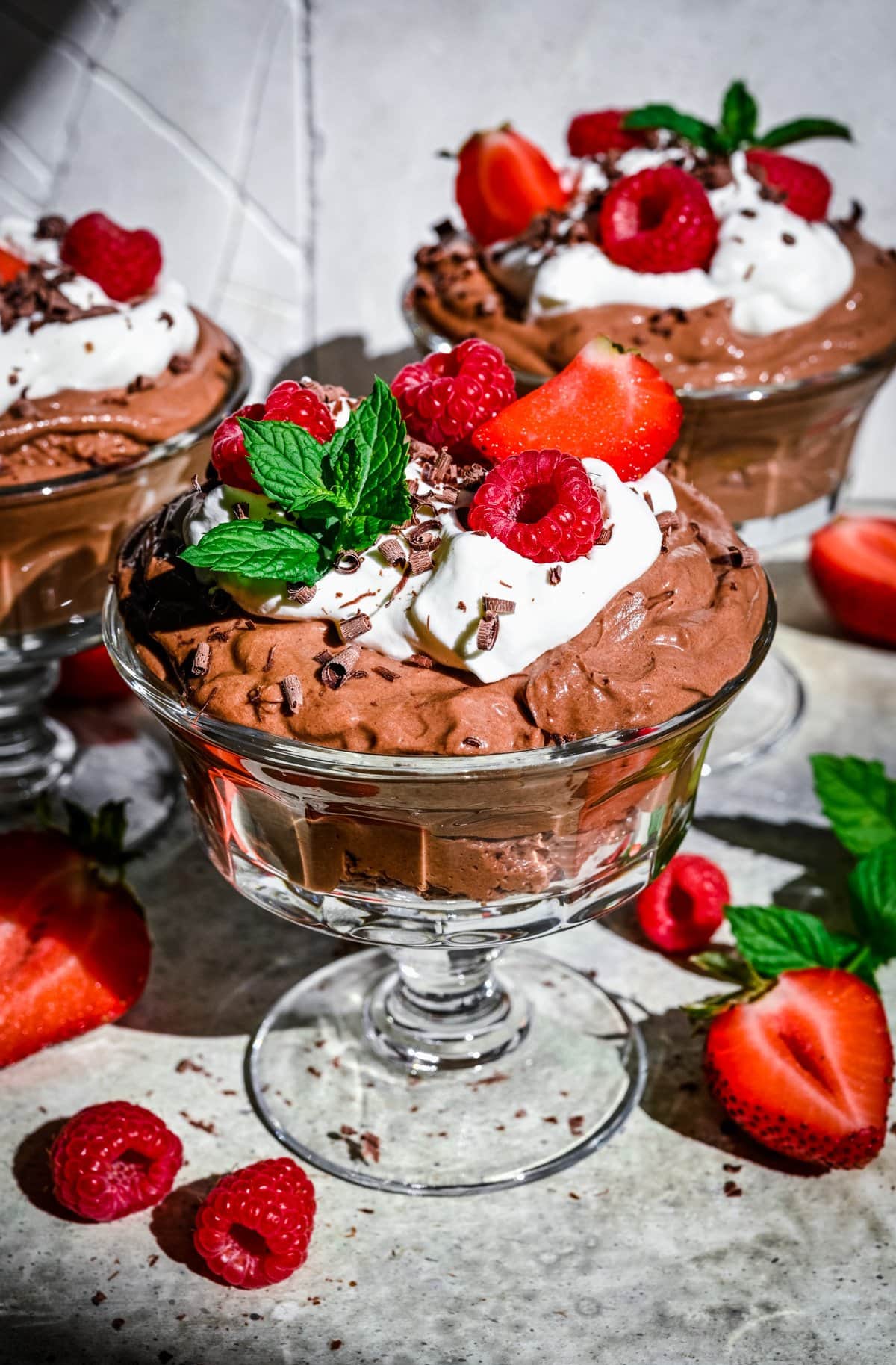 Finished tofu chocolate mousse in glass jars with toppings.