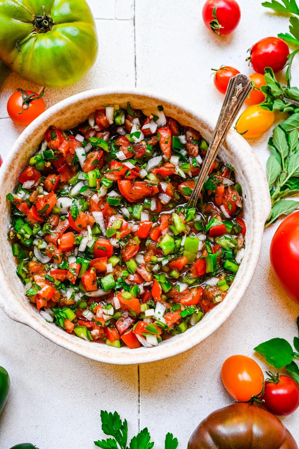 Overhead of finished tomato relish with a spoon in the bowl.