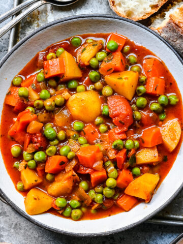 Overhead view of pea stew in a white bowl.