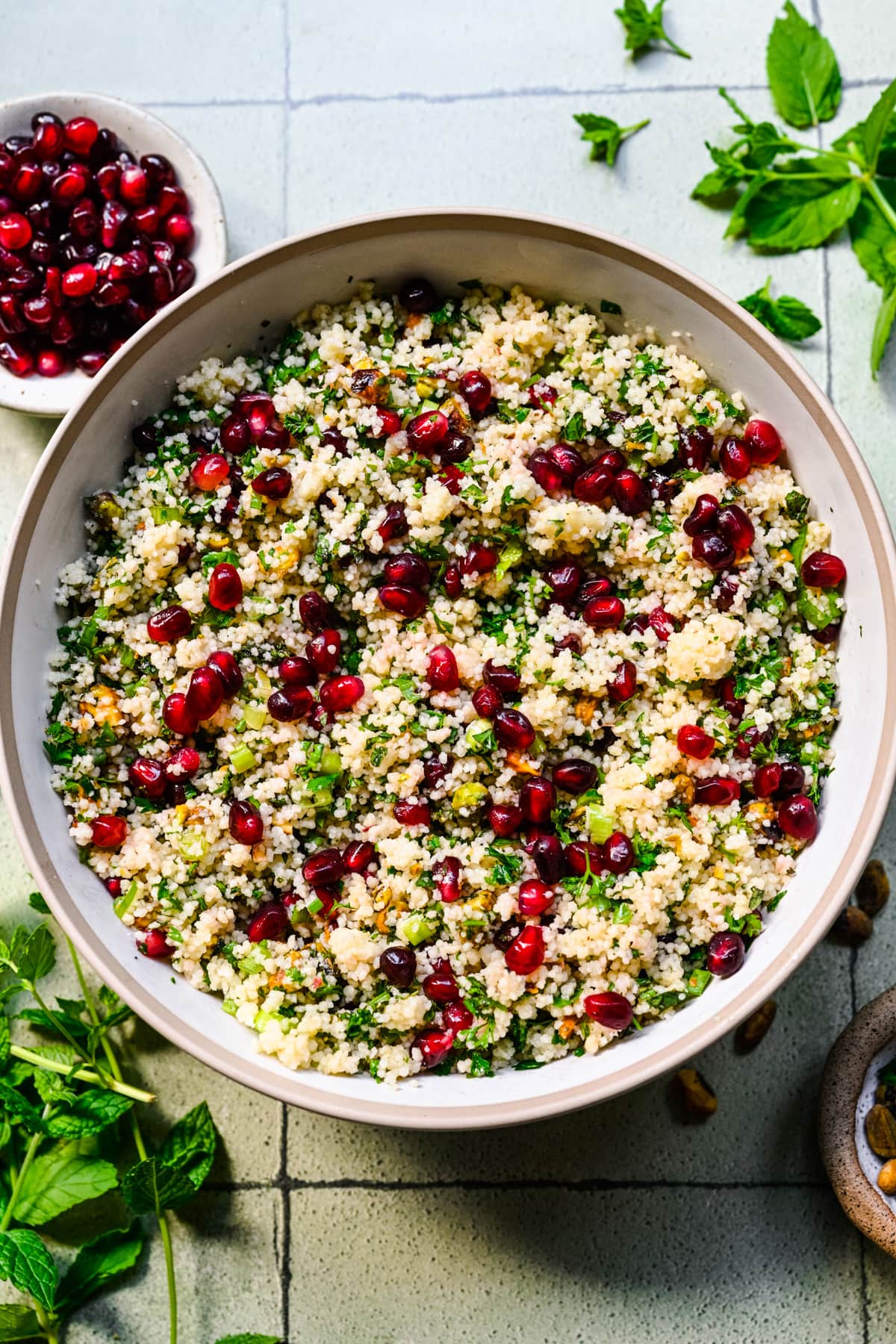 Finished pomegranate couscous salad in a white bowl.