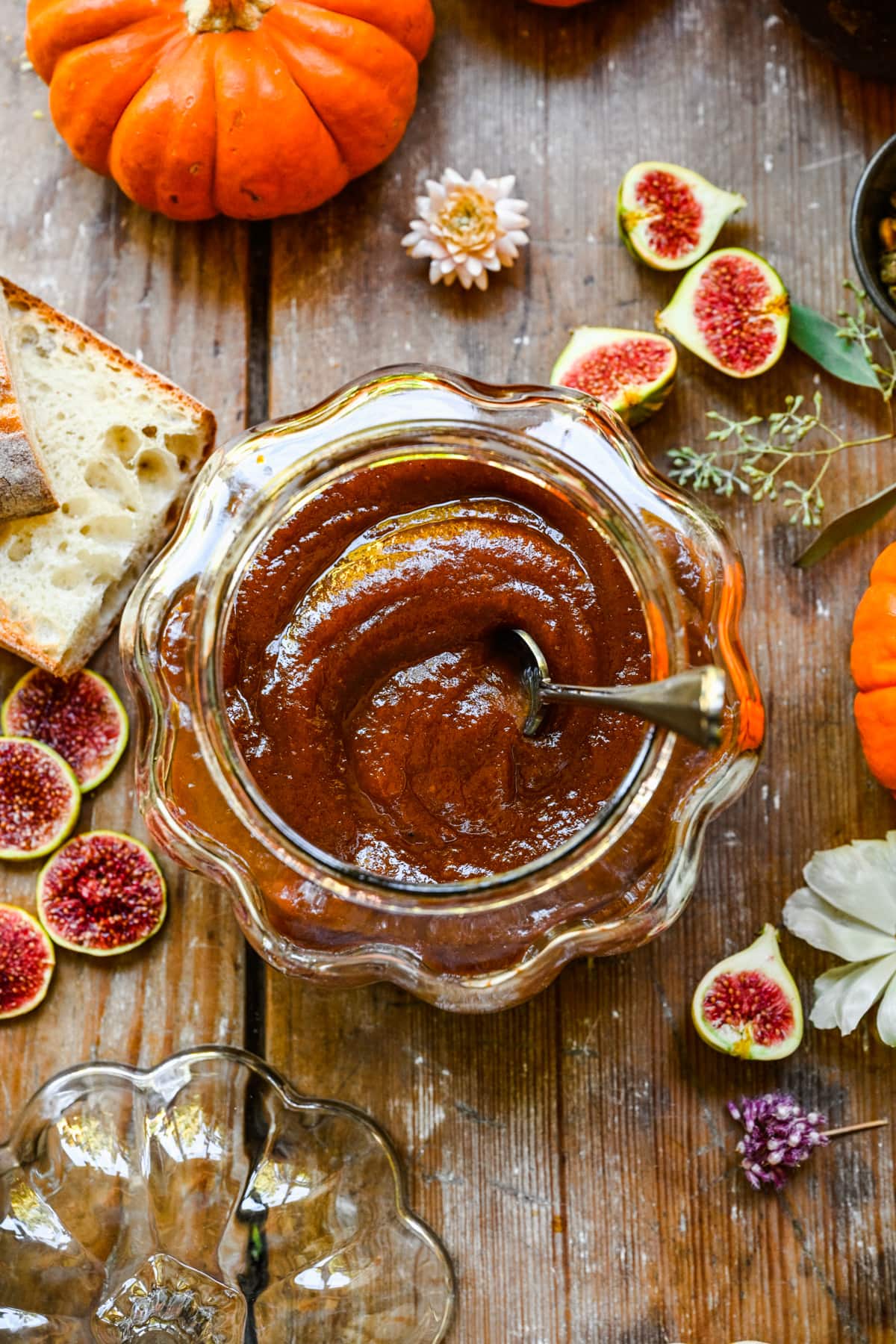 Overhead of finished pumpkin butter in a glass pumpkin with a spoon.