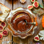 Overhead of pumpkin butter in a glass pumpkin with a spoon.