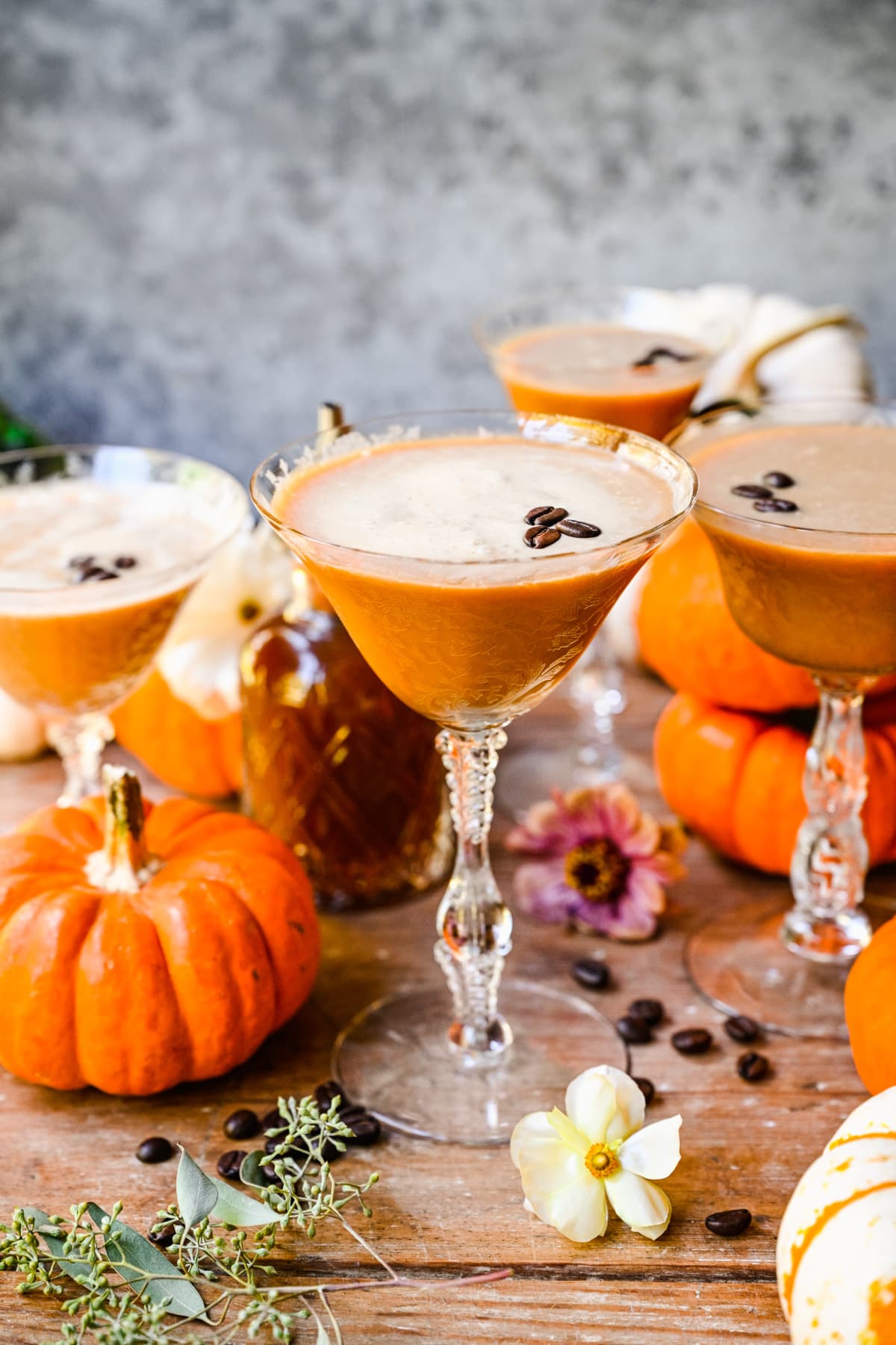 Finished espresso martinis in glasses with decor in background.