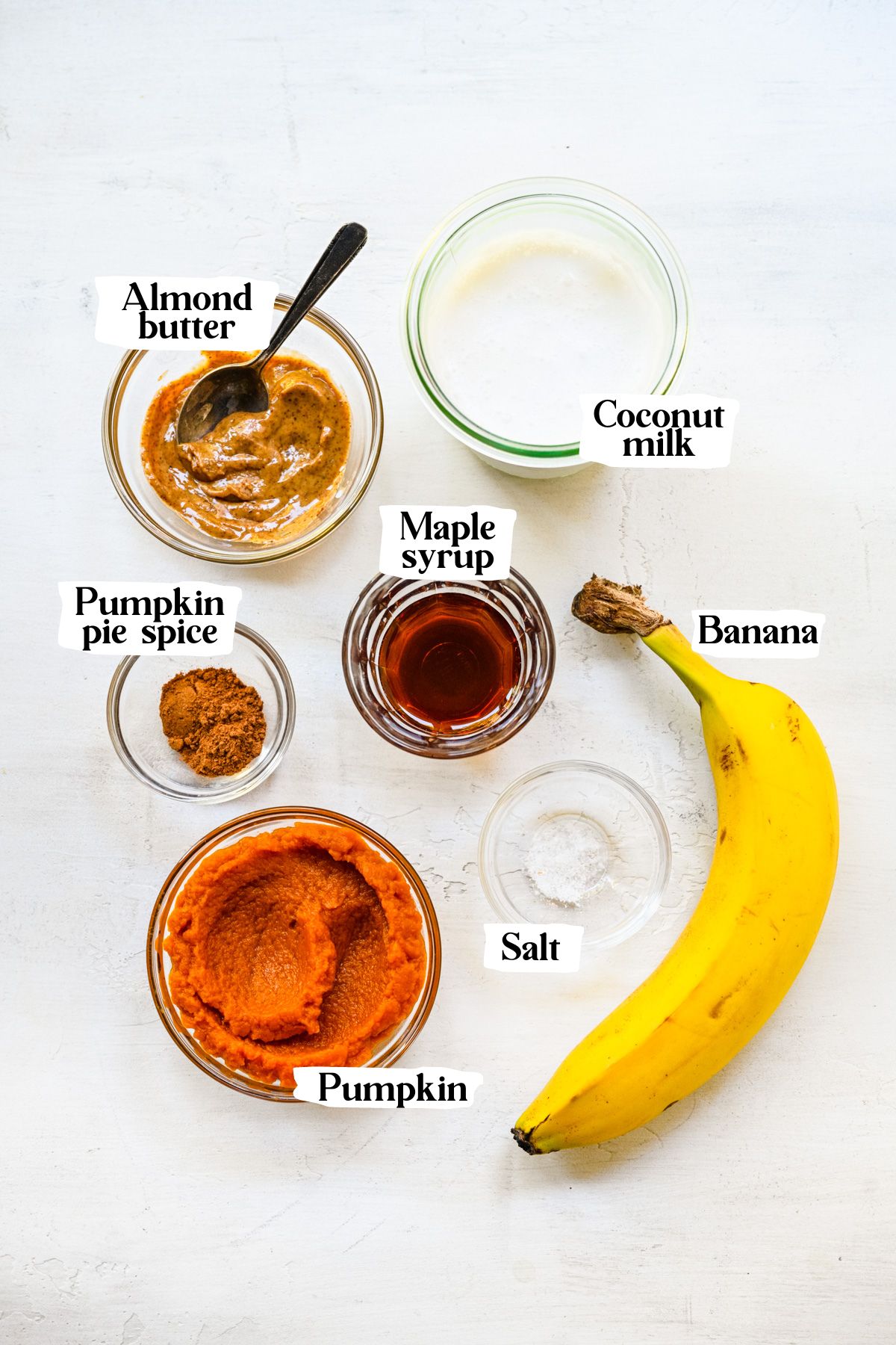 Overhead of pumpkin pie smoothie ingredients including pumpkin and banana.