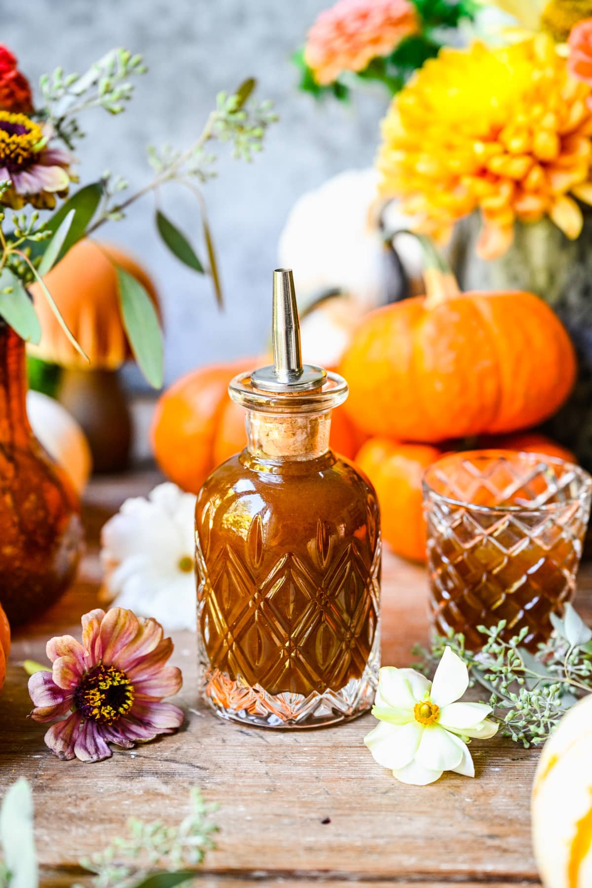 Finished pumpkin spice simple syrup in a glass bottle with fall decor. 