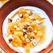 Overhead view of stewed pears atop yogurt in a bowl.