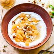 Overhead view of stewed pears atop yogurt in a bowl.