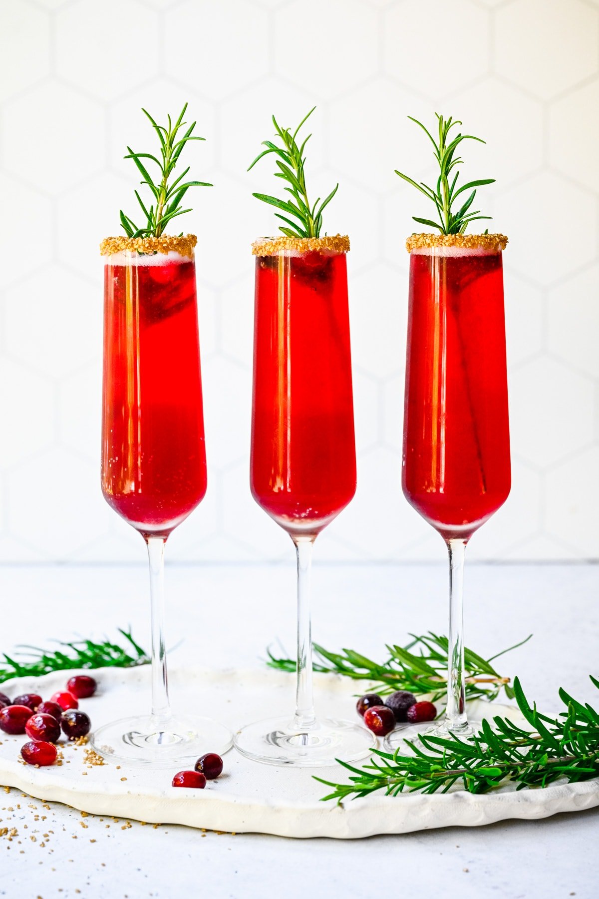 Finished cranberry mimosas in glasses with garnish.