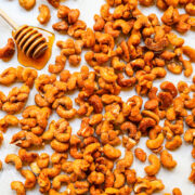 Overhead view of honey roasted cashews on a white background.