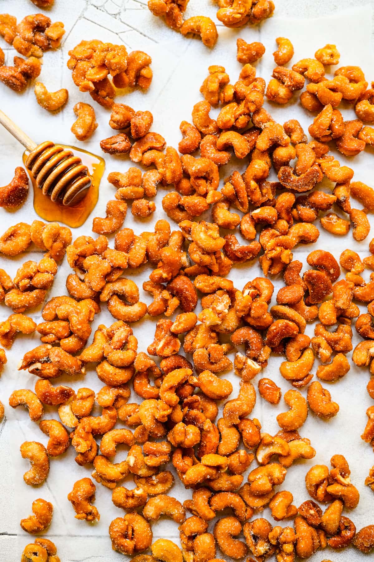 Overhead view of honey roasted cashews on a white background.