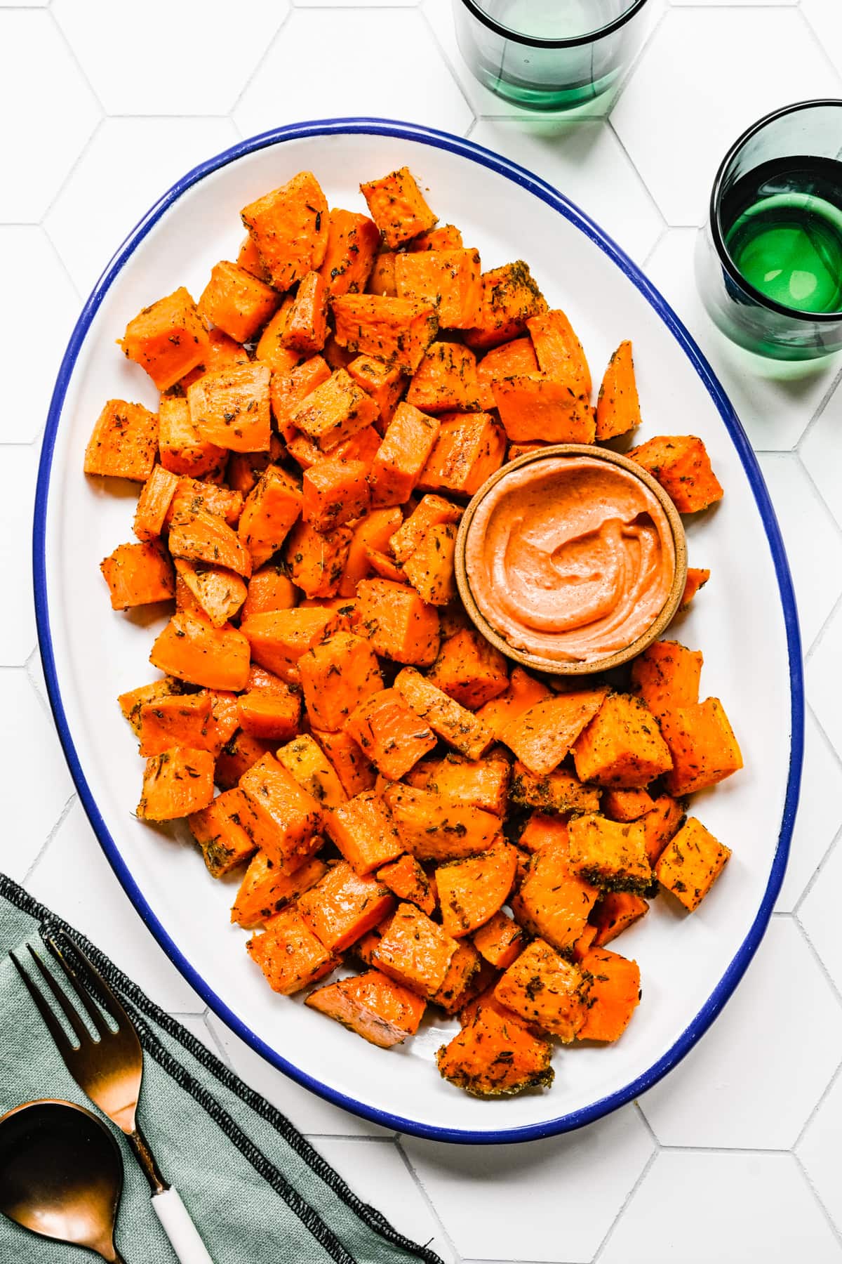 Finished roasted sweet potatoes on a white platter.