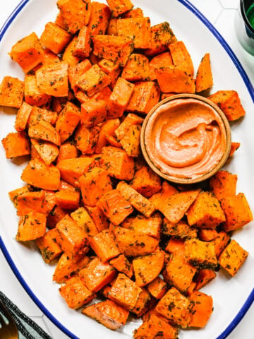 Close up of the finished roasted sweet potatoes on a white platter.