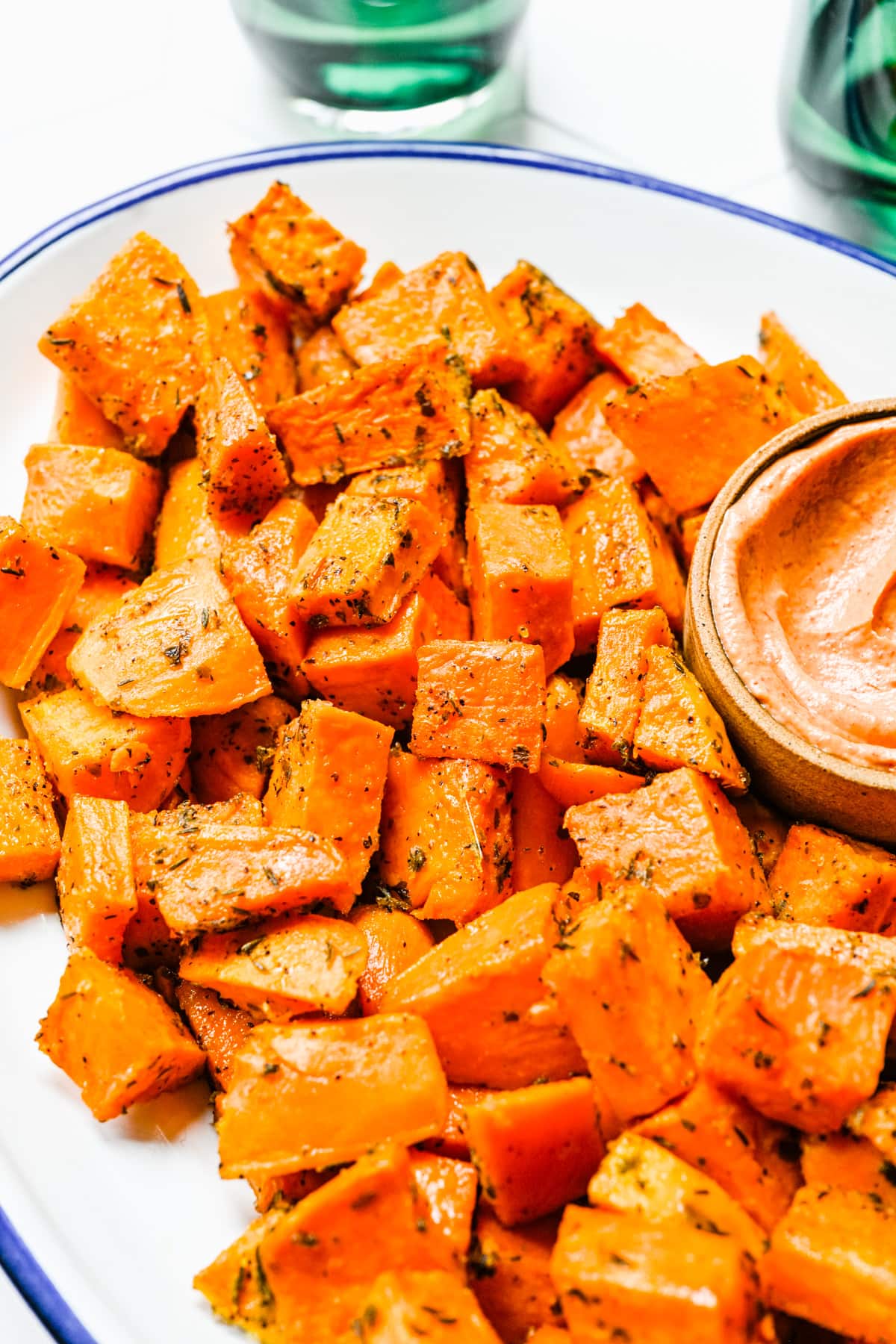 Close up of the finished roasted sweet potatoes with a dipping sauce.