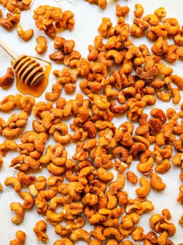 Overhead view of honey roasted cashews on a white background.