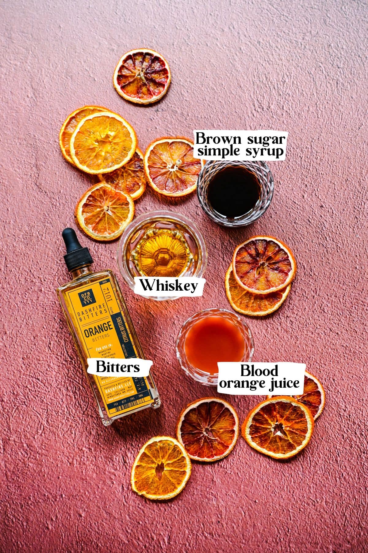 Blood orange old fashioned ingredients including whiskey and bitters.