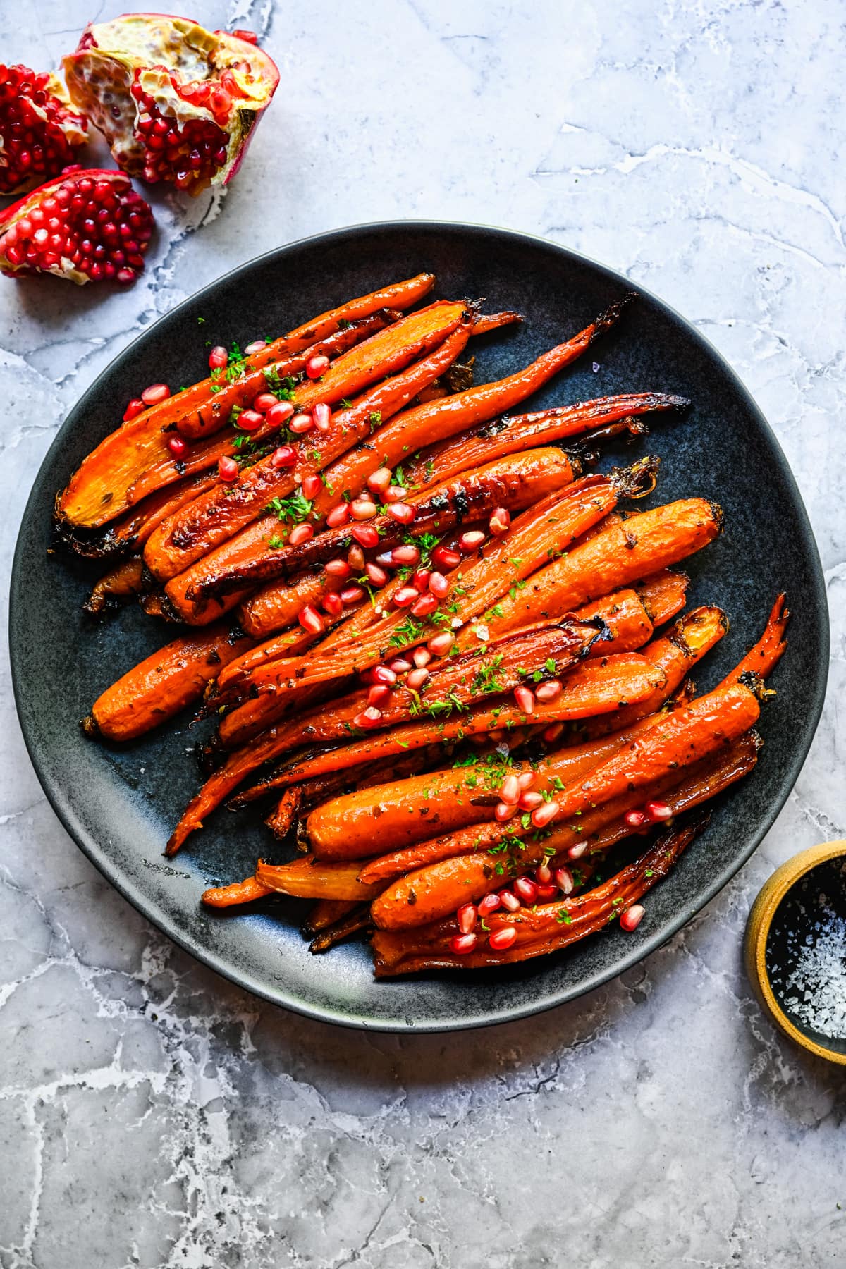 Overhead view of brown sugar honey glazed carrots on a black plate.