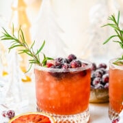 Front view of mistletoe margarita with sugared cranberries and rosemary garnish.