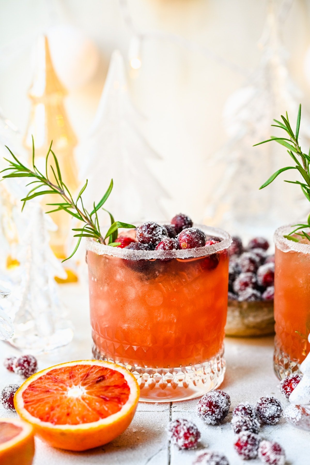 Front view of mistletoe margarita with sugared cranberries and rosemary garnish.